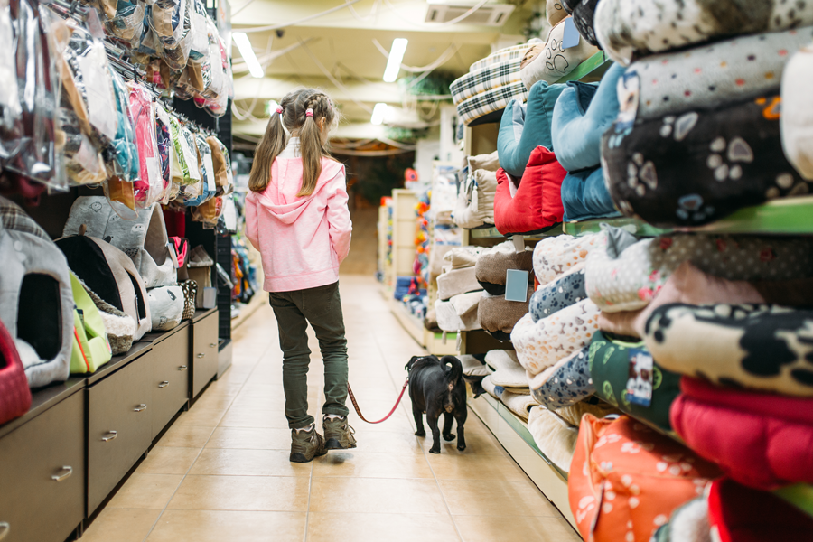 girl and dog in pet store aisle